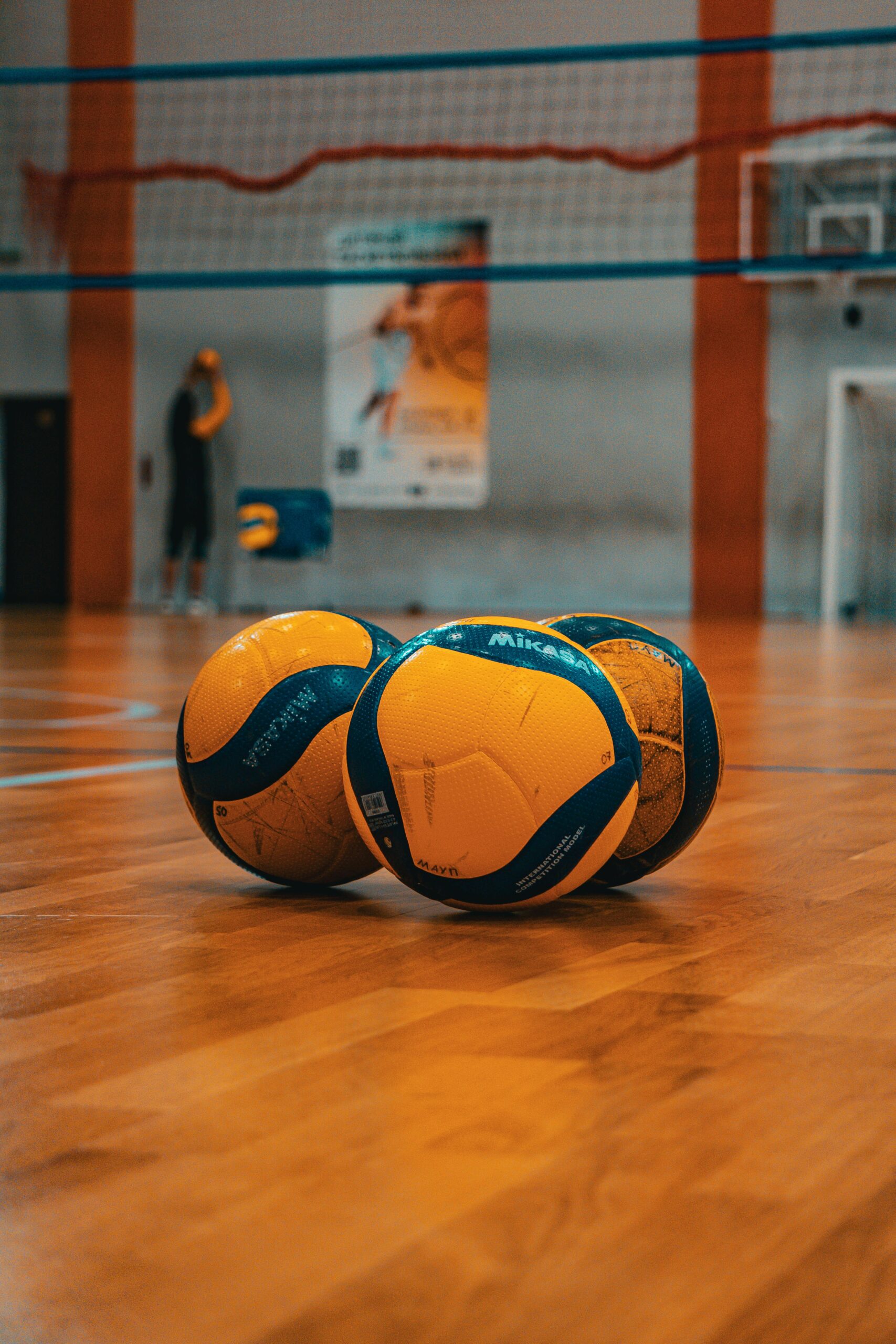 Three volleyballs on a sports court in Kyiv, Ukraine. Ideal for athletic and sports themes.